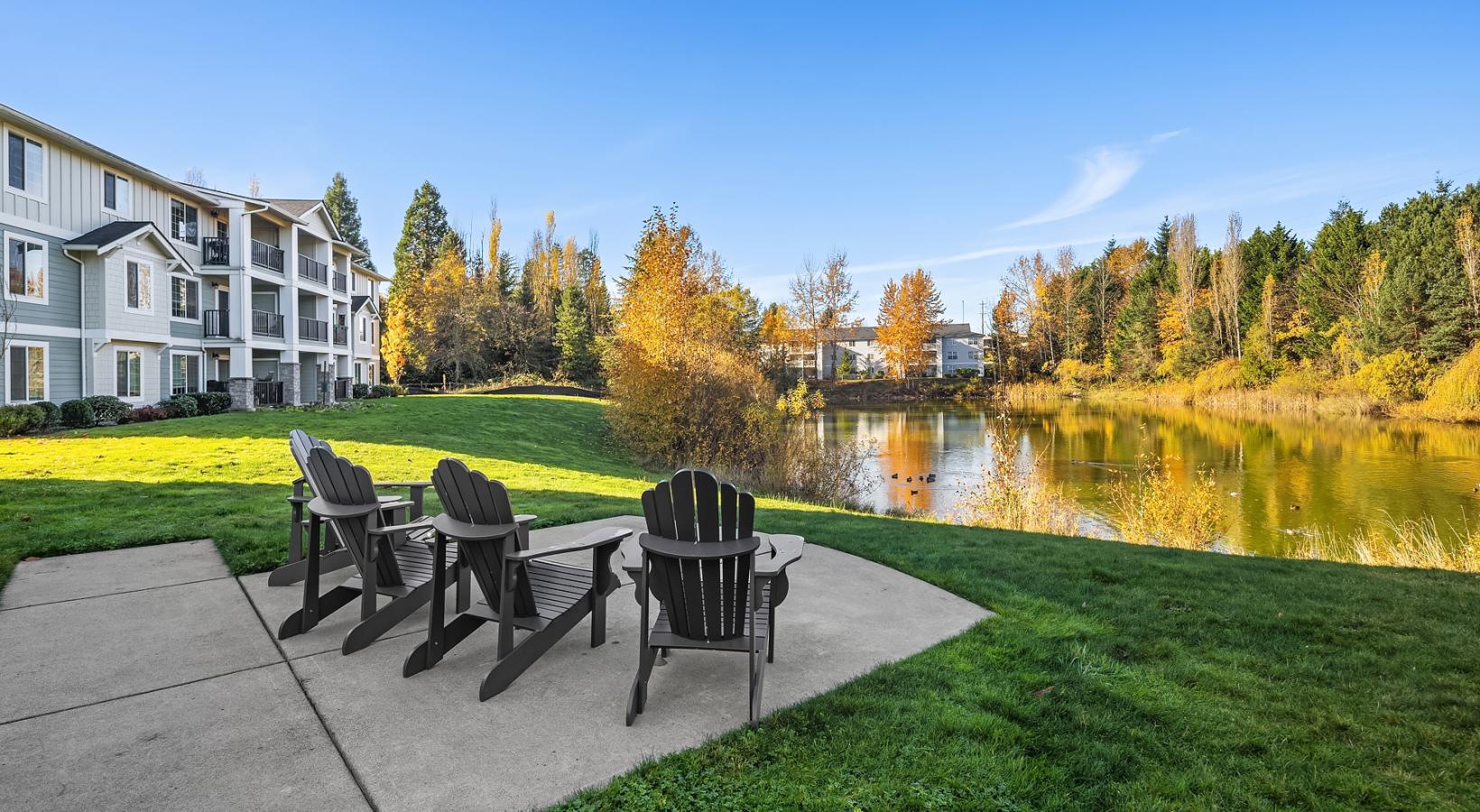 a group of chairs and tables next to a pond