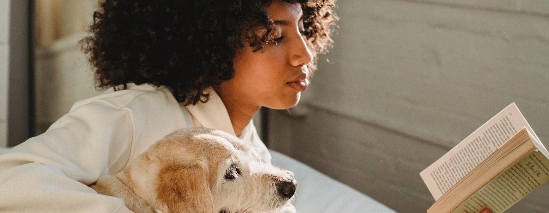a person reading a book to a dog